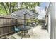 Outdoor patio featuring a dining table, umbrella, comfortable chairs, string lights, and privacy fence at 1620 W New York St, Indianapolis, IN 46222