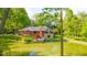 The home's rear features a cozy deck and solar panels, set against the backdrop of a serene pond and natural landscape at 1633 W 200 North, Greenfield, IN 46140