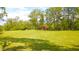 Expansive backyard with lush lawn, mature trees, and a red storage shed surrounded by green grass at 1633 W 200 North, Greenfield, IN 46140