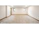 Spacious carpeted basement featuring neutral paint, modern windows, and a door leading outside at 1633 W 200 North, Greenfield, IN 46140