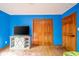 Bedroom with blue walls, hardwood floors, and barn door closet with TV on storage unit at 1633 W 200 North, Greenfield, IN 46140