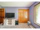 Bedroom featuring carpet, purple walls, wood closet doors, and TV on storage cabinet at 1633 W 200 North, Greenfield, IN 46140