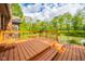 Spacious wooden deck with railing overlooks a serene pond and lush landscaping at 1633 W 200 North, Greenfield, IN 46140