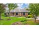 A well-maintained brick home featuring a stone accent, lush lawn, and mature landscaping in a tranquil setting at 1633 W 200 North, Greenfield, IN 46140