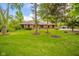 A beautiful brick home has a well-maintained lawn and lush landscaping and is surrounded by mature trees at 1633 W 200 North, Greenfield, IN 46140