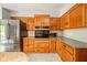 Well-lit kitchen featuring stainless steel refrigerator, wooden cabinets and granite countertops at 1633 W 200 North, Greenfield, IN 46140