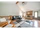 An inviting living room with vaulted ceilings, a brick fireplace, and a gray modern decor rug creates a cozy atmosphere at 1633 W 200 North, Greenfield, IN 46140