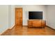 Living room showcasing wood floors and a vintage media cabinet beneath a modern flatscreen TV at 1633 W 200 North, Greenfield, IN 46140