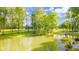 A serene view of the pond and the landscape featuring mature trees and the residence, creating a private oasis at 1633 W 200 North, Greenfield, IN 46140