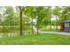 Picturesque view of a sprawling yard with mature trees, a pond, and a charming outbuilding at 1633 W 200 North, Greenfield, IN 46140