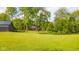 Picturesque yard with mature trees and a glimpse of the charming outbuilding in the distance at 1633 W 200 North, Greenfield, IN 46140