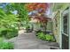 Well maintained backyard deck surrounded by mature trees, shrubs, and plants with outdoor seating at 1748 Sweet Gum Dr, Indianapolis, IN 46260