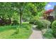 Lush backyard with walkway, green lawn, mature trees, and plenty of space for outdoor activities at 1748 Sweet Gum Dr, Indianapolis, IN 46260