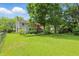 Expansive backyard featuring mature trees, lush lawn, and a charming home exterior at 1748 Sweet Gum Dr, Indianapolis, IN 46260