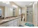 Well-lit bathroom featuring a double vanity with a marble countertop, shower, and white cabinets at 1748 Sweet Gum Dr, Indianapolis, IN 46260