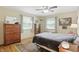 Bedroom with hardwood floors, ceiling fan, wooden dresser, and bed with comfortable bedding at 1748 Sweet Gum Dr, Indianapolis, IN 46260