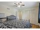 Comfortable bedroom featuring hardwood floors, ceiling fan, closet, and bed with patterned bedding at 1748 Sweet Gum Dr, Indianapolis, IN 46260