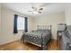 Cozy bedroom with hardwood floors, ceiling fan, window, and a comfortable bed with patterned bedding at 1748 Sweet Gum Dr, Indianapolis, IN 46260