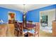 Dining area with blue walls, hardwood floors, and view to the kitchen at 1748 Sweet Gum Dr, Indianapolis, IN 46260