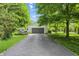 A long driveway leads to this home's large, two car garage, surrounded by lush trees and lawn at 1748 Sweet Gum Dr, Indianapolis, IN 46260