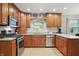Well-lit kitchen features wooden cabinets, stainless steel appliances, and granite countertops at 1748 Sweet Gum Dr, Indianapolis, IN 46260