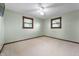 Empty bedroom with carpeted floor, ceiling fan, and natural light from two windows at 1891 W 300 N, Anderson, IN 46011
