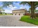 A three-car detached garage with gravel driveway and mature trees provides lots of outdoor storage at 1891 W 300 N, Anderson, IN 46011