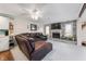 Cozy living room with a brick fireplace, TV, ceiling fan, and a comfortable brown leather couch at 1891 W 300 N, Anderson, IN 46011