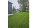 Expansive backyard featuring lush green lawn and mature trees, offering ample space for outdoor activities at 203 W 3Rd St, Sheridan, IN 46069