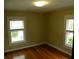 Bedroom with hardwood floors and two windows with blinds, neutral painted walls at 203 W 3Rd St, Sheridan, IN 46069