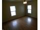 Bedroom featuring laminated wood floors, ceiling fan, and two windows at 203 W 3Rd St, Sheridan, IN 46069