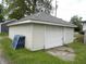 A detached garage featuring white siding, a well-maintained roof, and a clean white door at 203 W 3Rd St, Sheridan, IN 46069
