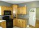 A kitchen featuring wood cabinets, black appliances, and laminate countertops at 203 W 3Rd St, Sheridan, IN 46069