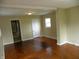 Open-concept living room with hardwood floors, neutral paint, and access to other rooms at 203 W 3Rd St, Sheridan, IN 46069