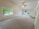 Bright living room featuring large windows, a ceiling fan, and neutral carpeting at 2035 Theodore Dr, Indianapolis, IN 46214