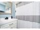 Modern bathroom with vanity, framed mirror, and shower with white and gray striped curtain at 2209 W 9Th St, Muncie, IN 47302