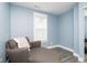 A bedroom with a chaise lounge, neutral colored walls, and a mirrored closet at 2209 W 9Th St, Muncie, IN 47302