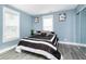 A bedroom with neutral colored walls, large windows, and a black and white bedspread at 2209 W 9Th St, Muncie, IN 47302