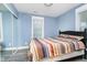 Bright bedroom with gray flooring, large windows, and a cozy bed with colorful striped covers at 2209 W 9Th St, Muncie, IN 47302