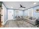 Spacious living room with light blue walls, a large sectional, and a modern ceiling fan at 2209 W 9Th St, Muncie, IN 47302