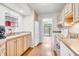 Functional kitchen featuring wood cabinets, white appliances, and easy access to backyard at 2267 Rome Dr # A, Indianapolis, IN 46228