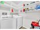 Bright laundry room equipped with modern white washer and dryer and ample storage shelves at 2267 Rome Dr # A, Indianapolis, IN 46228