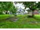 Fenced backyard with mature trees and a small home at 2622 Ethel Ave, Indianapolis, IN 46208