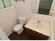 Bathroom area with tile walls, toilet, and vanity sink with wood cabinet at 2622 Ethel Ave, Indianapolis, IN 46208