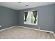 Bedroom with a window with patterned curtains, grey walls, and carpet at 2622 Ethel Ave, Indianapolis, IN 46208