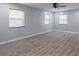 Spacious bedroom with ample natural light from three windows, complemented by vinyl floors and a ceiling fan at 3735 Marrison Pl, Indianapolis, IN 46205