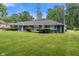 Wide shot of a blue brick single-story home with a green lawn and trees at 3735 Marrison Pl, Indianapolis, IN 46205