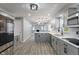 Bright, updated kitchen boasts gray cabinets, stainless steel appliances, quartz counters and an island with pendant lighting at 3735 Marrison Pl, Indianapolis, IN 46205