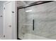 Close-up of the bathtub and tiled shower with black trim and sliding glass doors at 3735 Marrison Pl, Indianapolis, IN 46205
