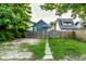 Backyard view of a blue house with wooden fence, showing a walkway and parking area at 3764 Ruckle St, Indianapolis, IN 46205